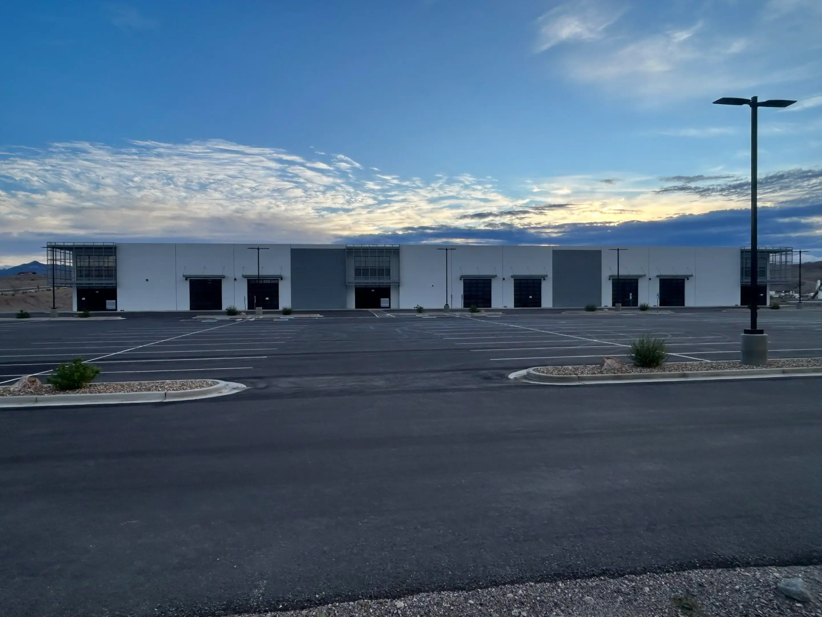 Empty warehouse complex under dramatic sunset sky