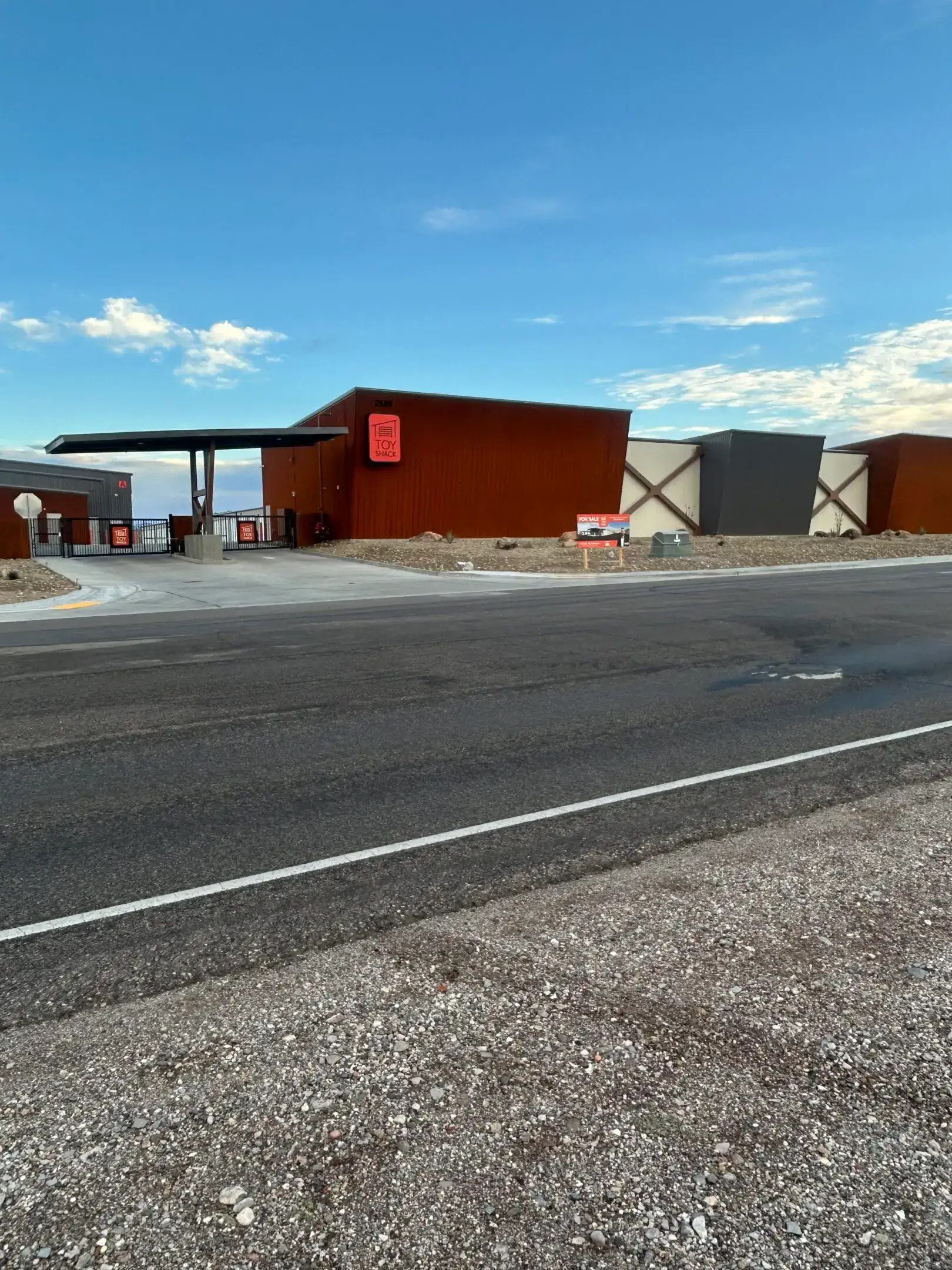 Rust-colored roadside building with canopy and sign